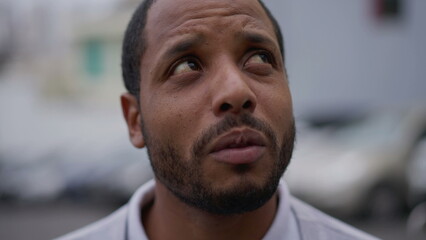 One anxious young African American man in distress closeup face. Portrait of a black person with worried preoccupied emotion