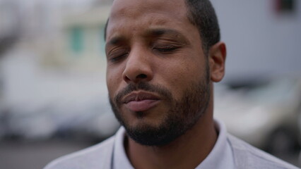 One anxious young African American man in distress closeup face. Portrait of a black person with...