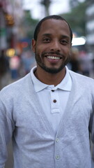 Portrait of a black man standing in street looking at camera. Closeup face of an African American person