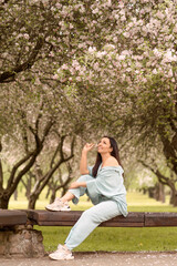 Naklejka premium girl with long dark hair in spring blooming garden