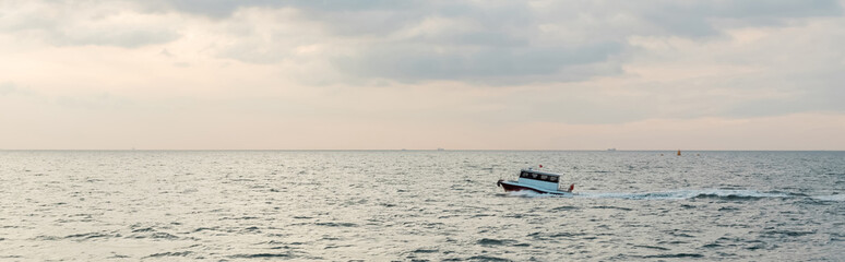 Fototapeta na wymiar modern white ship sailing in wavy sea on bosporus during sunset, banner.