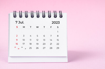Obraz na płótnie Canvas The July 2023 desk calendar for 2023 year on pink color background.