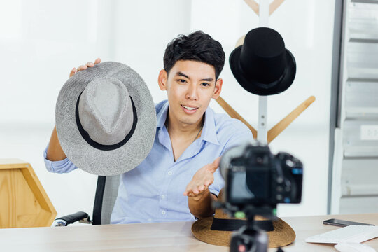 A Young Asian Influence Male Vlogger Selling Hats On Live Streaming, Youtuber Concept.