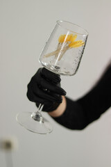 close-up of a glass in a hand. a glass with tassels. a girl is holding a glass. a wet glass close-up.