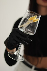 close-up of a glass in a hand. a glass with tassels. a girl is holding a glass. a wet glass close-up.