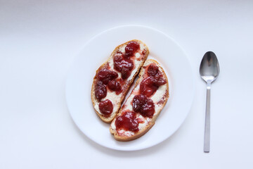 sandwich on a white plate.bread with butter and jam.sandwiches.strawberry jam.breakfast.bread with butter on a plate