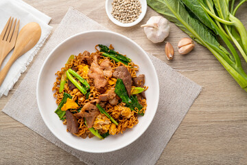 Stir-fried Instant Noodles with Soy Sauce and Pork in white plate.Asian food.Top view