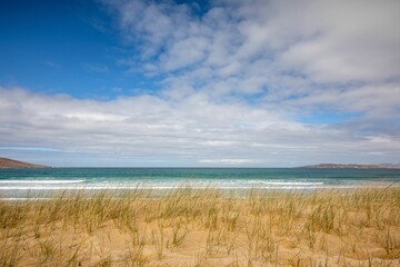 Beautiful Scarista Beach with the Atlantic ocean and hills in the background under a cloudy sky © Steven Jackson/Wirestock Creators