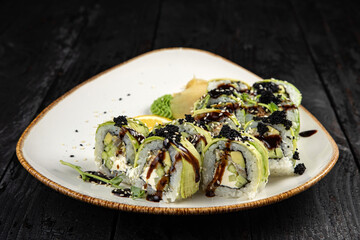 sushi roll with wasabi and sesame seeds on the plate. delicious food, close-up