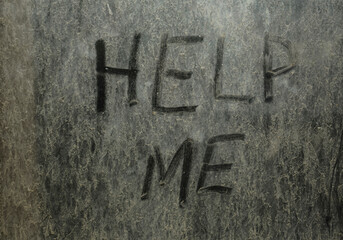 Words - inscription - help me - handwritten on dried dusty glass with grey dry dust.