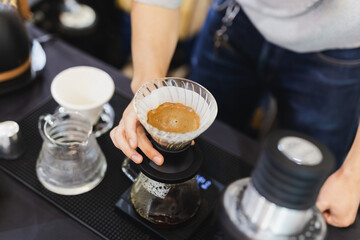 Fototapeta na wymiar Top view of barista brewing of coffee in paper filter.