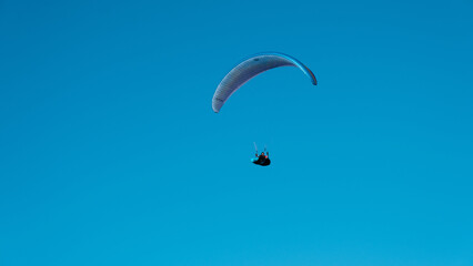 paraglider in a blue sky