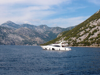 Bay of Kotor. Beautiful view of the pleasure yacht in the bay with mountains in the background. 