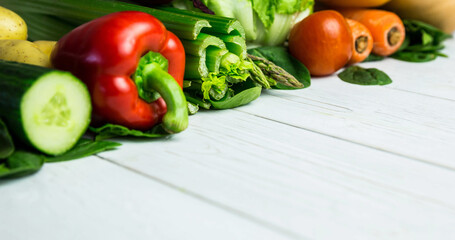 Close-up of fresh various raw vegetables arranged on wooden table, copy space