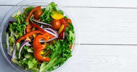 Directly above close-up shot of fresh vegetable salad served in glass bowl on table, copy space