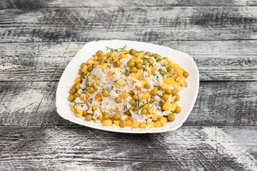 Rice, boiled rice with peas on a wooden white background
