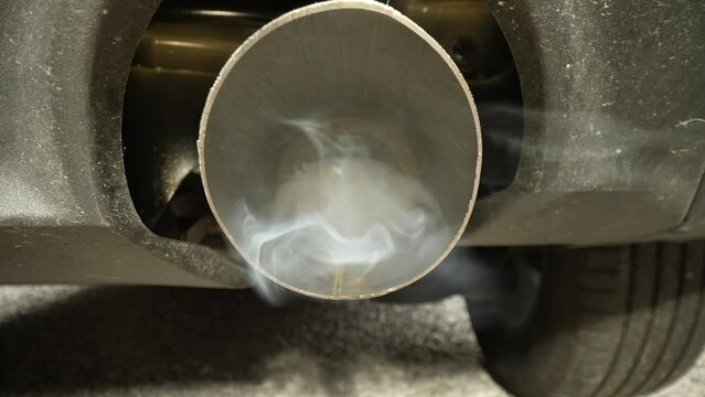 4K: Towards Exhaust Pipe on a Car emitting smoke fumes and pollution. Probe Lens Inside. Stock video clip footage