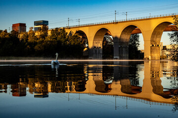 Fototapeta na wymiar Stockholm, Sweden The Arsta railway bridge on a foggy morning with a swan.