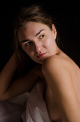 Portrait of beautiful slender young woman with blonde hair in a white bed in beautiful aesthetic poses