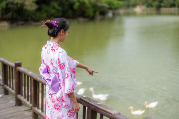 Asian woman wear Japanese yukata with the lake in countryside