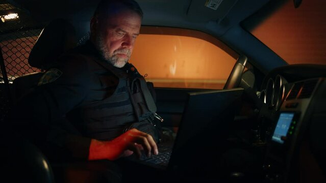 Inside Police Traffic Patrol Squad Car: White Male Police Officer on Duty Uses Laptop to Check Crime Suspect Background, License Plate, License and Registration. Officer of the Law Fight Crime