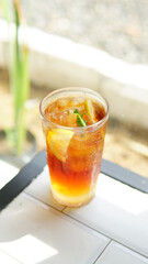 a glass of ice tea with mint and lemon on table