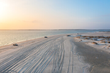 Aerial View of Trucks on the Beach Near the Inlet on Emerald Island Just Before Sunset