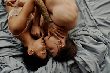 Top view of young sexy couple kissing on bed.