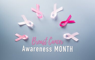 Pink ribbon on pastel paper background for supporting breast cancer awareness month campaign.