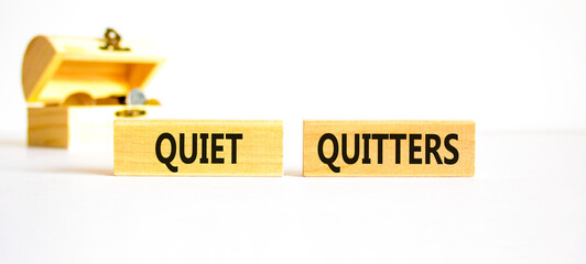 Quiet quitters symbol. Concept words Quiet quitters on wooden blocks. Beautiful white table white background. Wooden chest with coins. Business and quiet quitters concept. Copy space.