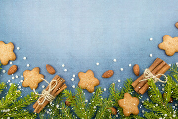 Slate background - copy space for Christmas and new year. Kitchen texture with cookies and flour. Fir branches and spices, cinnamon and nuts, snow