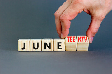 Juneteenth in June symbol. Concept words Juneteenth and June on wooden cubes. Beautiful grey table...