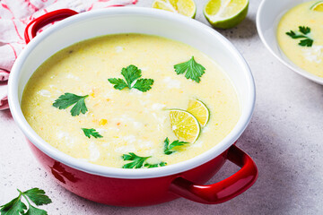 Corn soup in red pot. Vegan recipe concept.