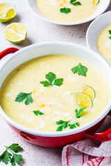 Corn soup in red pot. Vegan recipe concept.