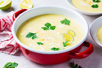 Corn soup in red pot. Vegan recipe concept.