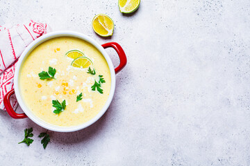 Corn soup in red pot. Vegan recipe concept.