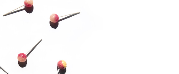 Lolipop candies lie on a white background. Top view, flat lay. Banner