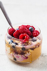 Overnight oatmeal with berry, peanut butter and maple syrup in jar. Healthy breakfast concept.