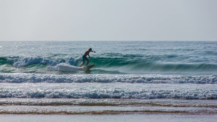 A man is surfing on a surfboard in Agadir beach