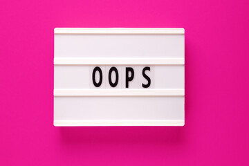 Lightbox with word oops on pink background. Apologies for a a mistake or error.