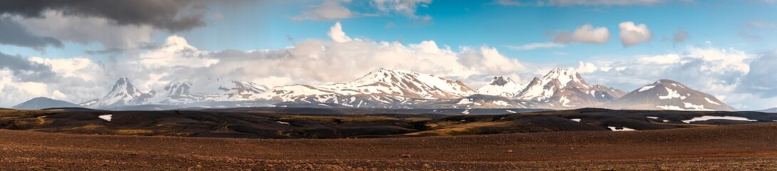 Panorama volcanic mountain range with snow covered on remote wilderness in Icelandic Highlands on summer