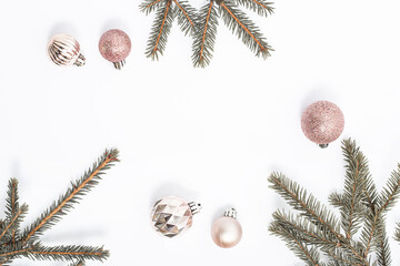 Decorative balls and sprigs of fir on a white background. Top view, flat lay.