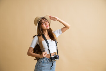 young attractive Asian woman traveler in casual clothes wearing straw hat with backpack and camera isolated on yellow background, Tourist girl having cheerful holiday trip concept - Powered by Adobe