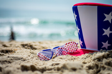 american flag hat and glasses on beach