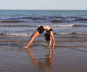 slender girl back to back while doing Yoga meditation exercises and doing OM symbol