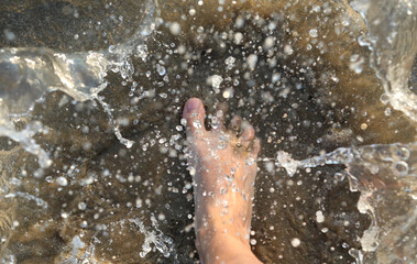 splashes of sea water and the foot of the person