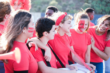 Fototapeta premium Group of soccer team fans together cheering and having a good time outdoors