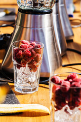 Frozen raspberries and ice in a glass. Preparation of vitamin cocktails. Selective focus. Close-up