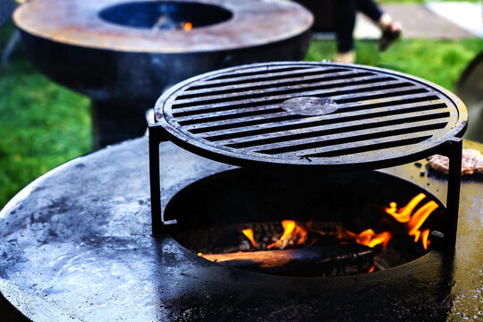 Industrial barbecue in a street cafe. Large brazier for cooking on fire and coals. Foreground