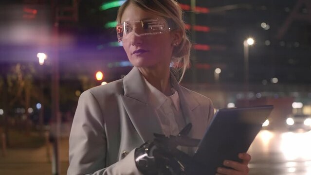 Cinematic footage of a business woman with cyborg bionic arm and augmented reality visor. Representation of the future that will include human being and tech parts - cyberpunk look video
